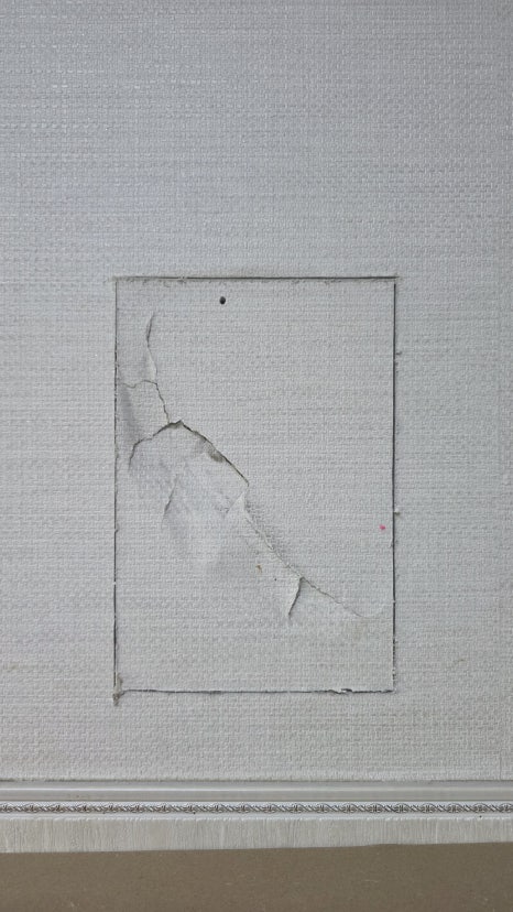 Damaged drywall cut into a clean rectangular opening