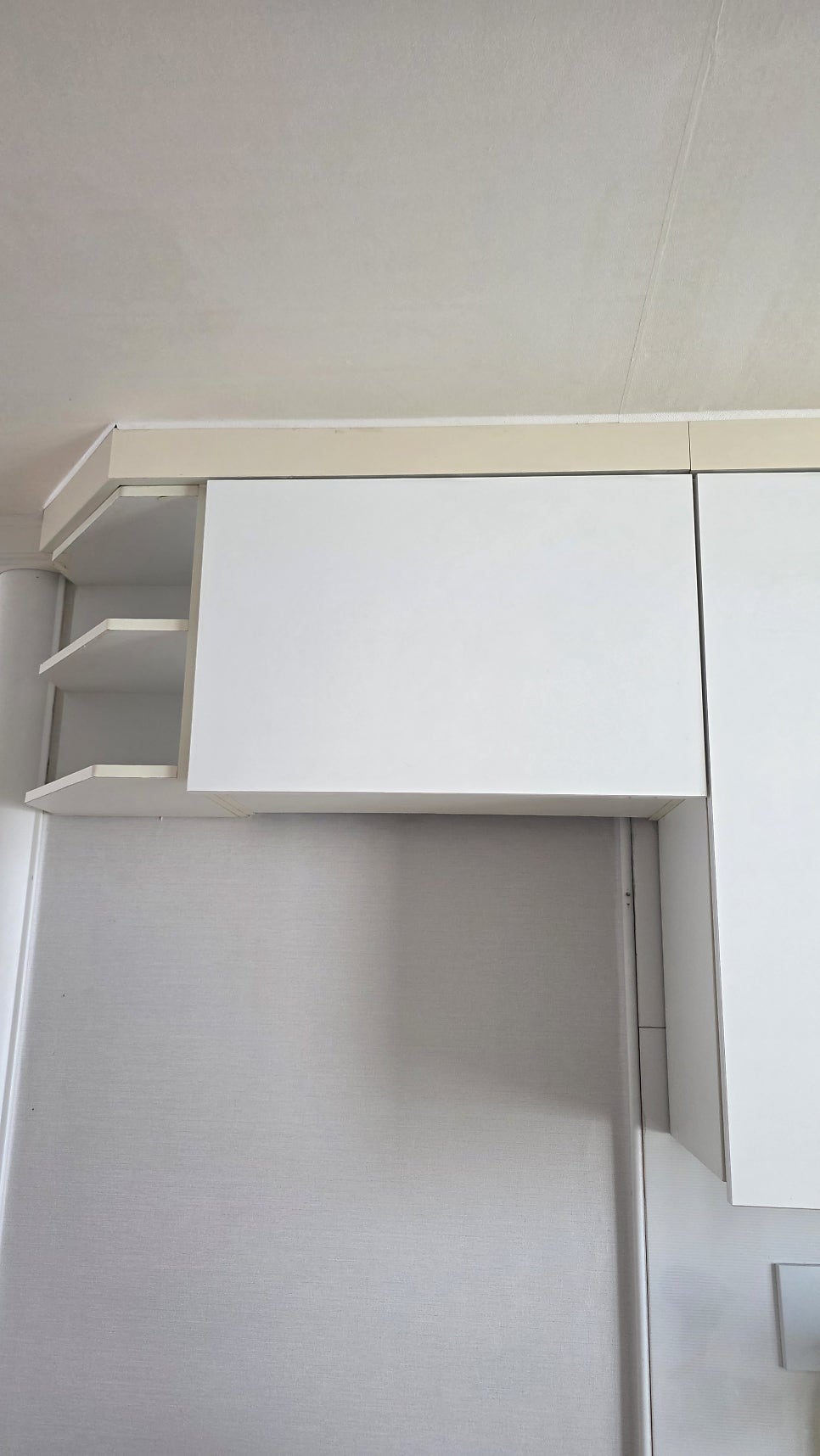 Raised kitchen upper cabinet creating clearance for a tall refrigerator